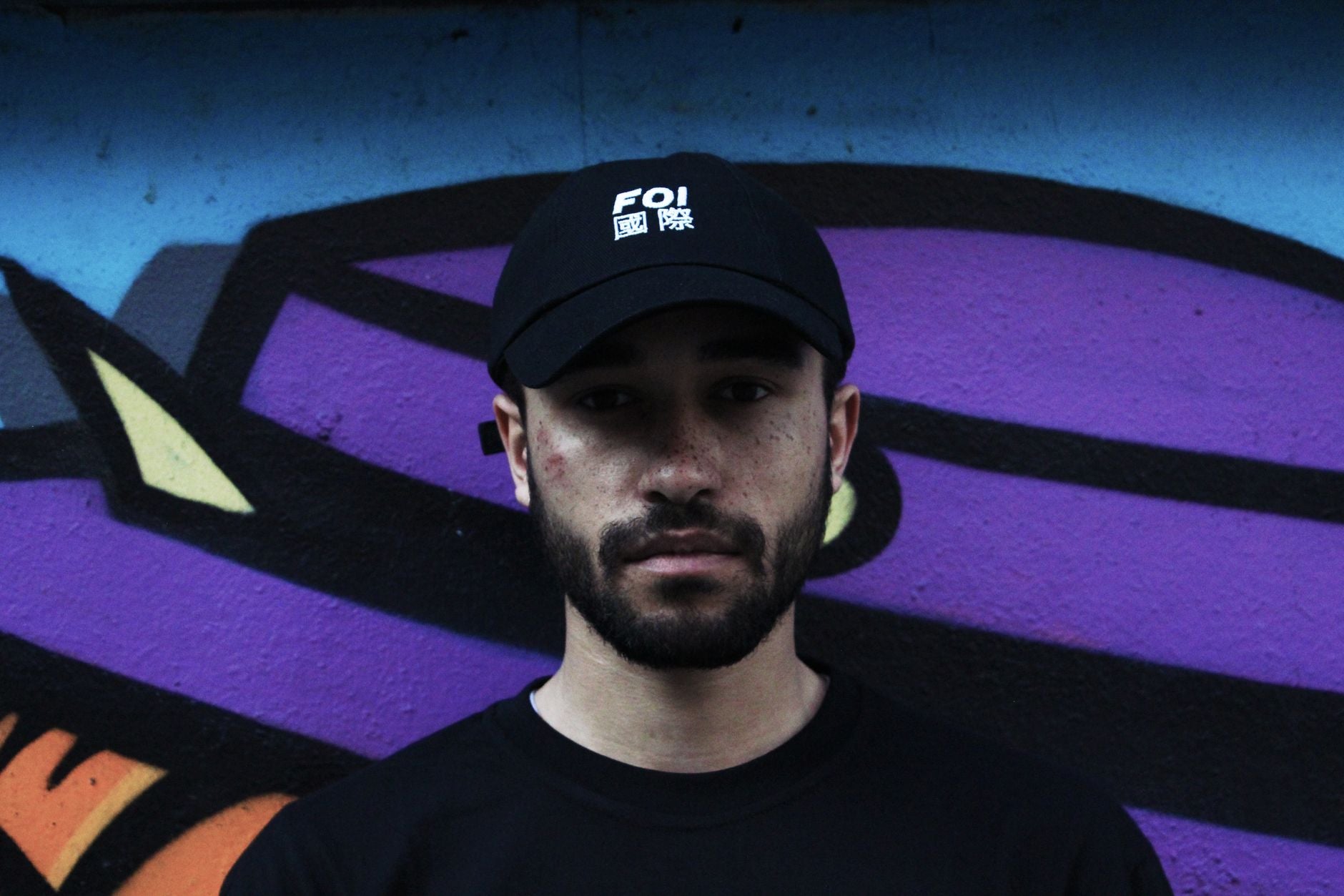 Jeune homme portant une casquette streetwear avec un hoodie oversize et un look urbain complet