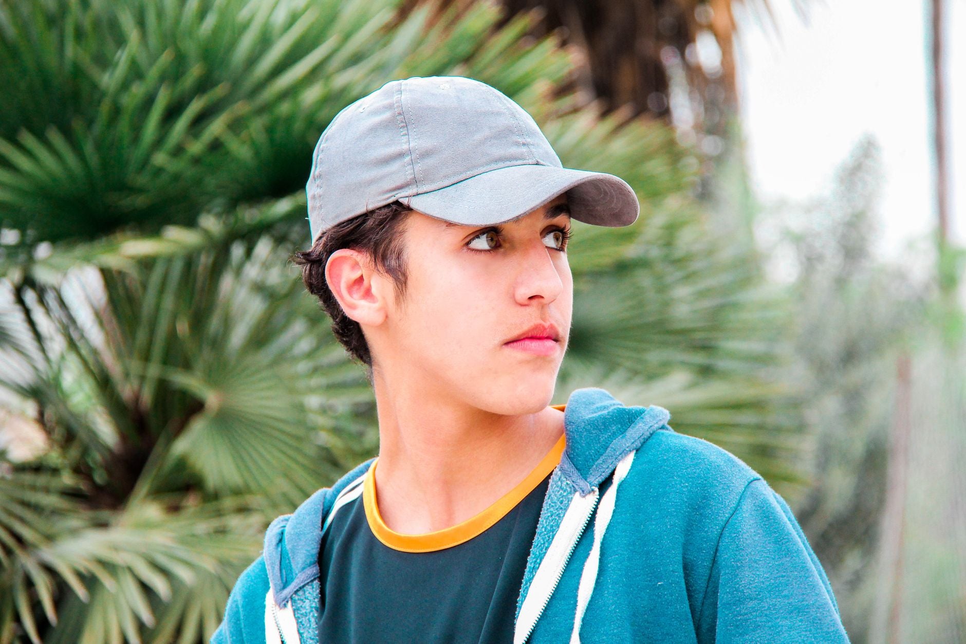 Jeune homme portant une casquette grise unie dans un look streetwear décontracté