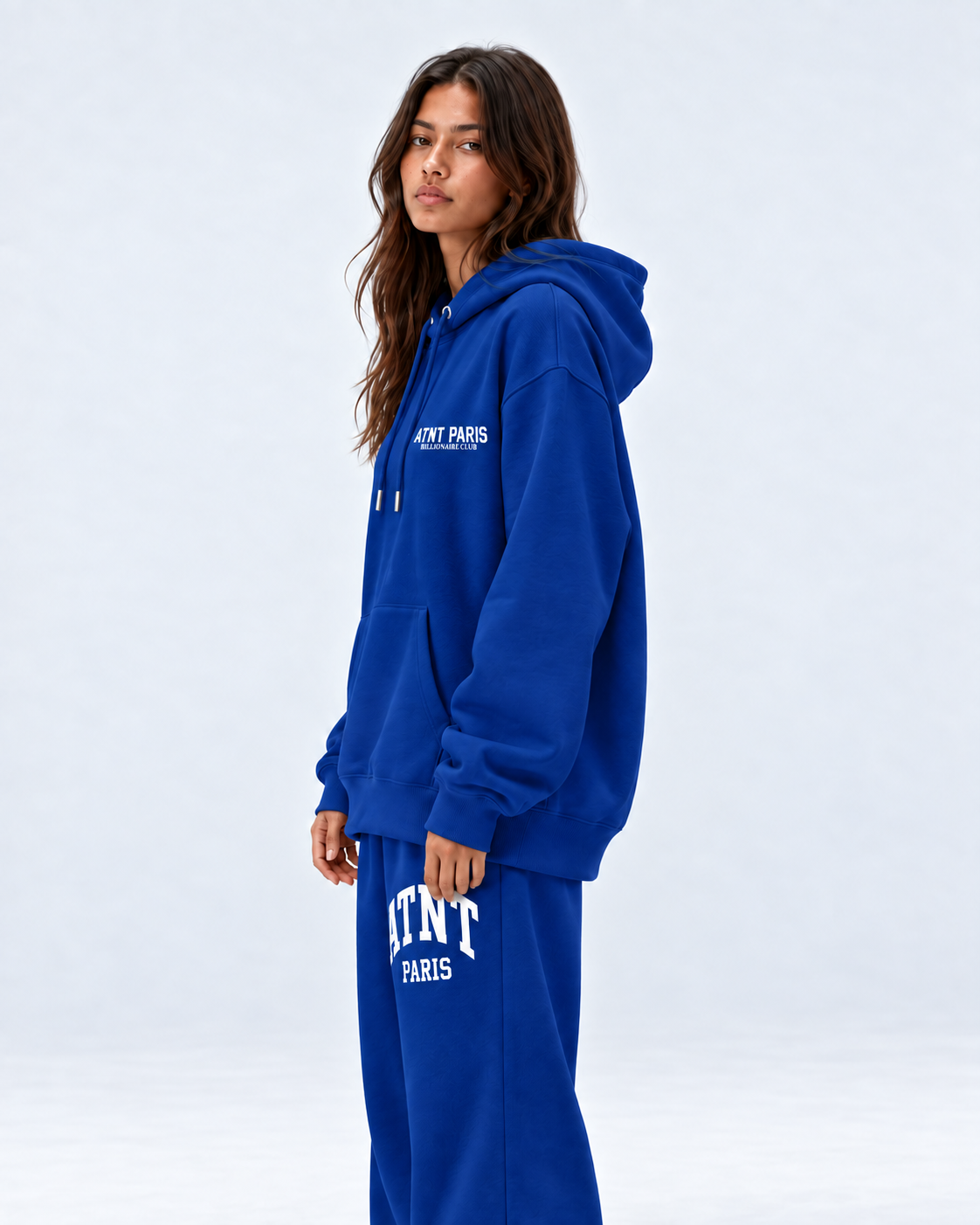 Sweat Billionaire Club bleu ATNT PARIS — porte profil, studio gris clair