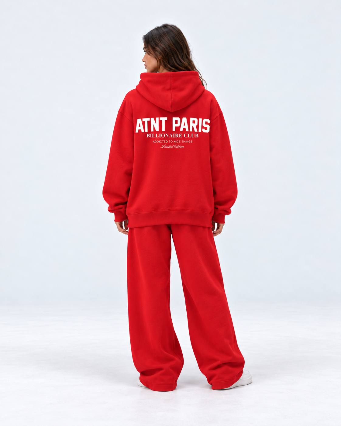 Sweat Billionaire Club rouge ATNT PARIS — porte dos tourne, coupe portée ample, studio gris clair