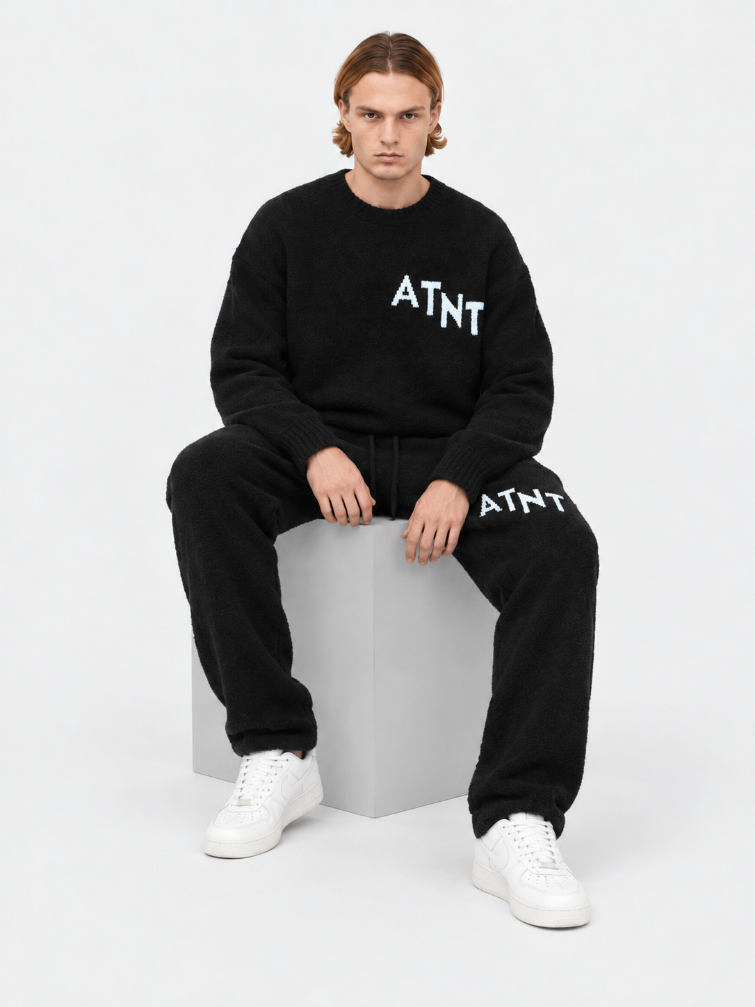 ATNT Tracksuits studio : Pull Oversize Noir Effet Cachemire, vue assise sur fond gris clair