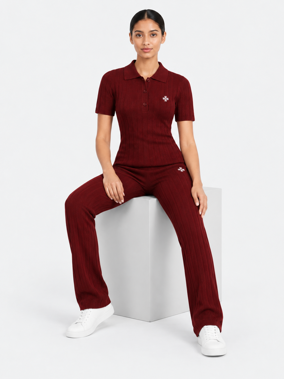 ATNT Tracksuits studio : Pantalon riviera ATNT Signature en maille côtelée Bordeaux, vue assise sur fond gris clair
