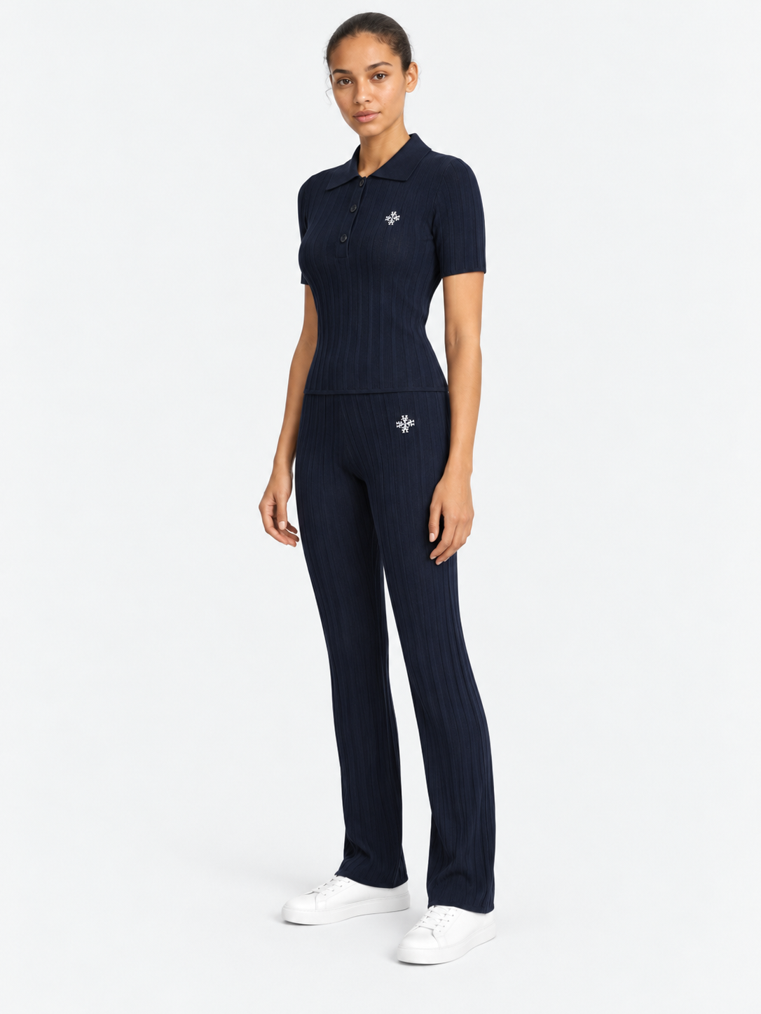 ATNT Tracksuits studio : Pantalon riviera Atnt Signature en maille côtelée Navy, vue de trois quarts sur fond gris clair