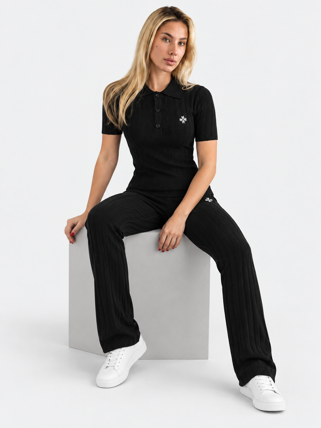 ATNT Tracksuits studio : Polo Maille Côtelée ATNT Signature Noir, vue assise sur fond gris clair