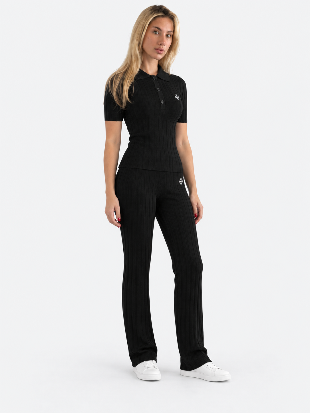 ATNT Tracksuits studio : Pantalon riviera ATNT Signature en maille côtelée Noir, vue de trois quarts sur fond gris clair
