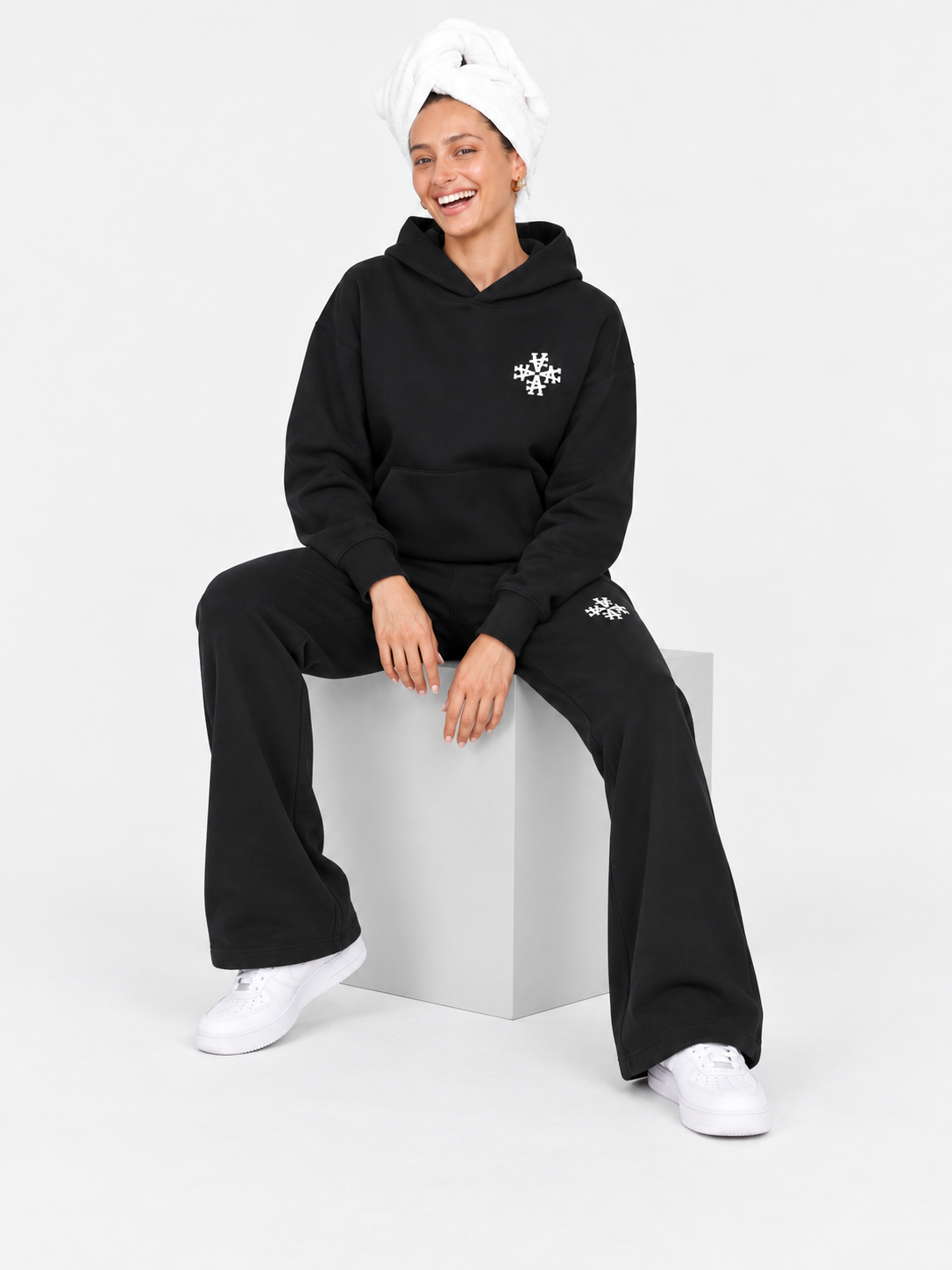 ATNT Tracksuits studio : Ensemble de Survêtement Femme Signature Noir, vue assise sur fond gris clair