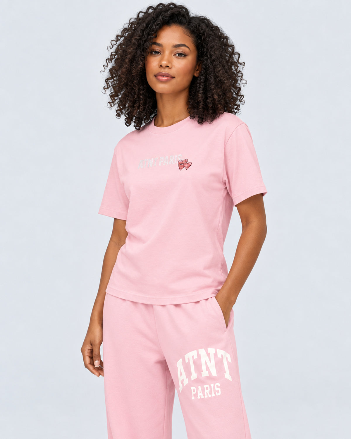 T-shirt Love Heart Strass rose clair ATNT PARIS — porté de trois quarts face, plan rapproché — studio gris clair, mannequin femme