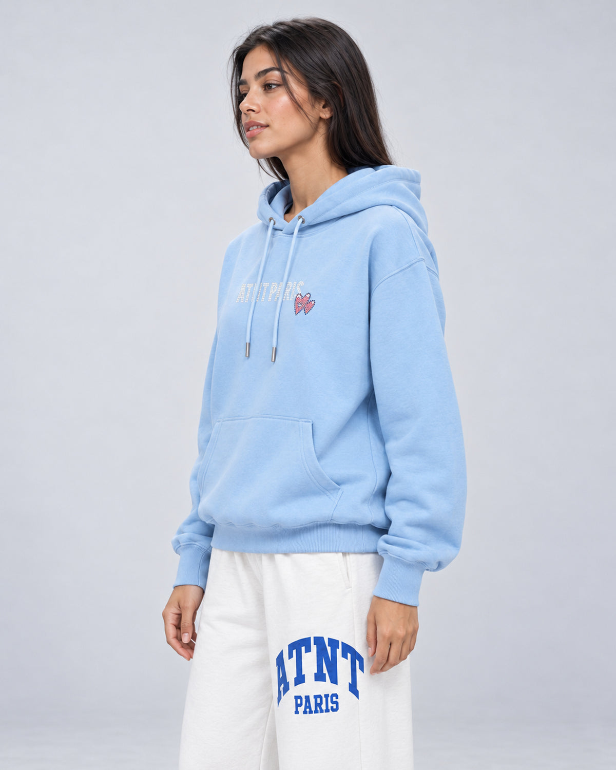 Sweat Capuche Bleu Ciel Love heart Strass ATNT PARIS — Pack studio naturel — mannequin femme, vue latérale rapprochée — fond gris clair