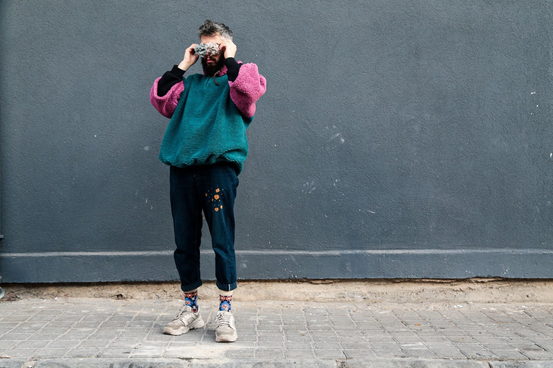Jeune homme portant un pull en cachemire beige dans un look streetwear urbain décontracté
