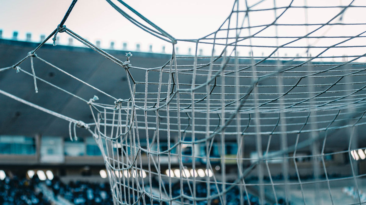 Filet de but de football dans un stade, ambiance tenue match de foot et look supporter