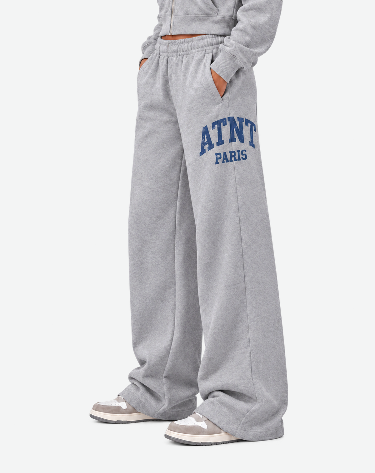 Jogging femme ATNT PARIS Heather Grey, détail coupe et bas de jambe, fond gris neutre