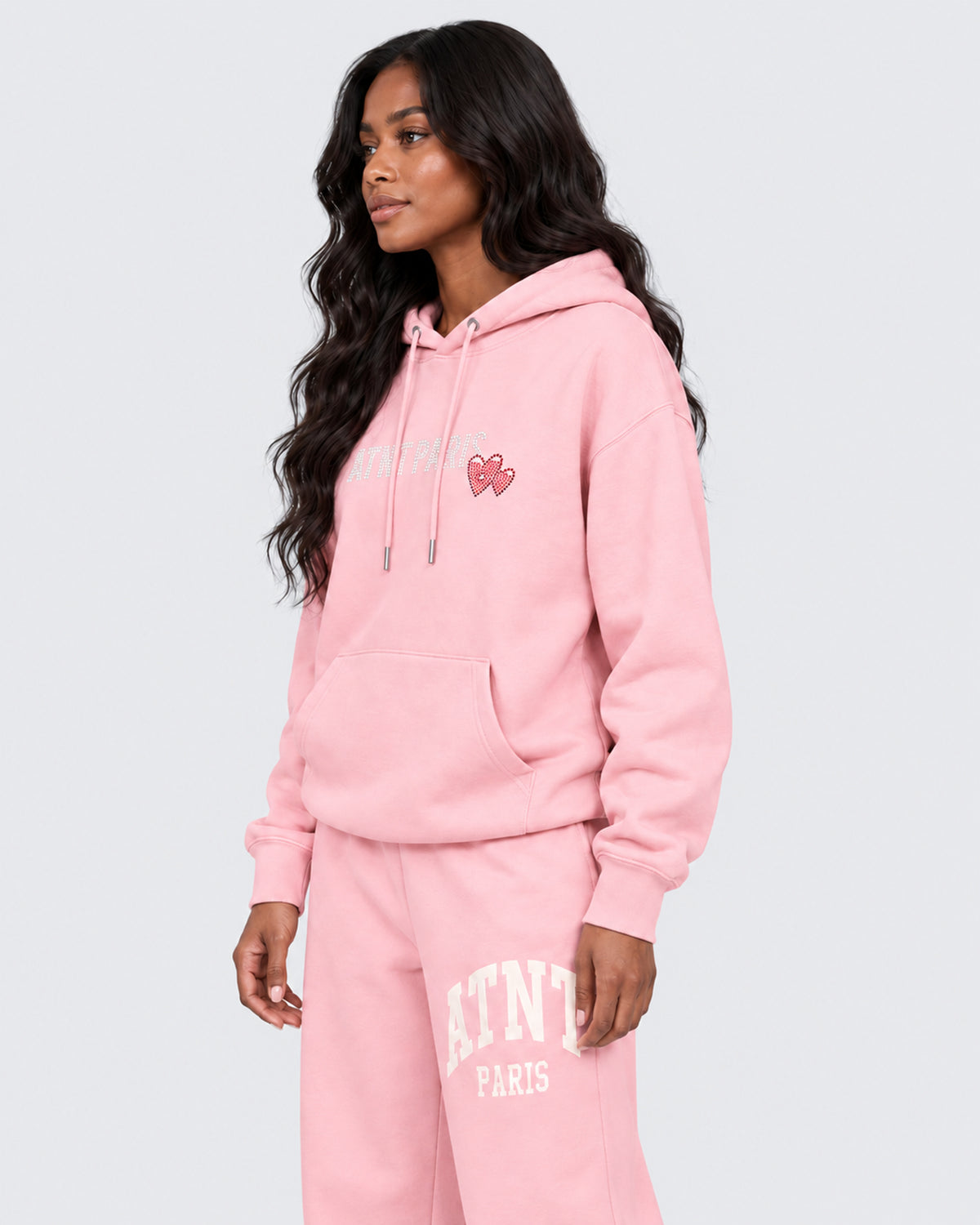 Sweat Capuche Rose Clair Love heart Strass ATNT PARIS — Pack studio naturel — mannequin femme, vue latérale rapprochée — fond gris clair