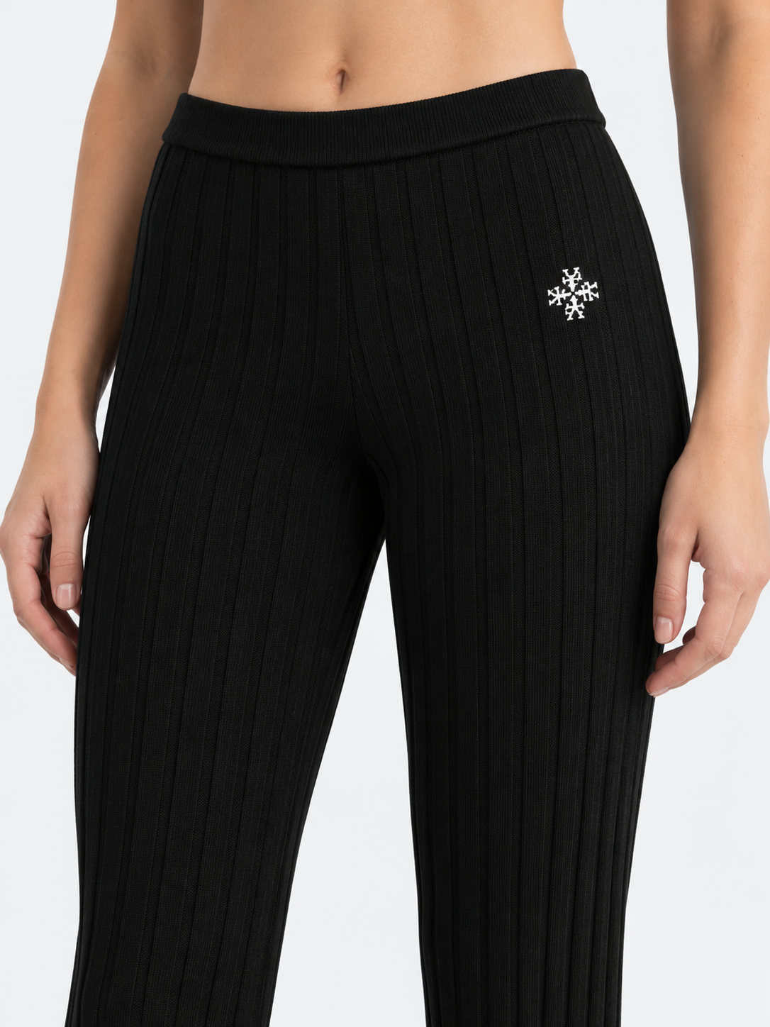 ATNT Tracksuits studio : Pantalon riviera ATNT Signature en maille côtelée Noir, détail de la matière sur fond gris clair