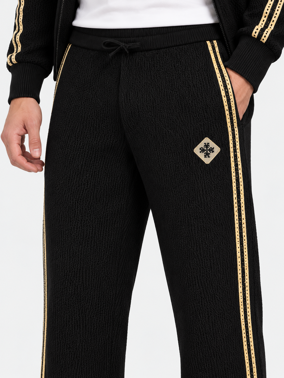 ATNT Tracksuits studio : Pantalon de Survêtement Signature Noir  – Détail Crochet, détail de la matière sur fond gris clair