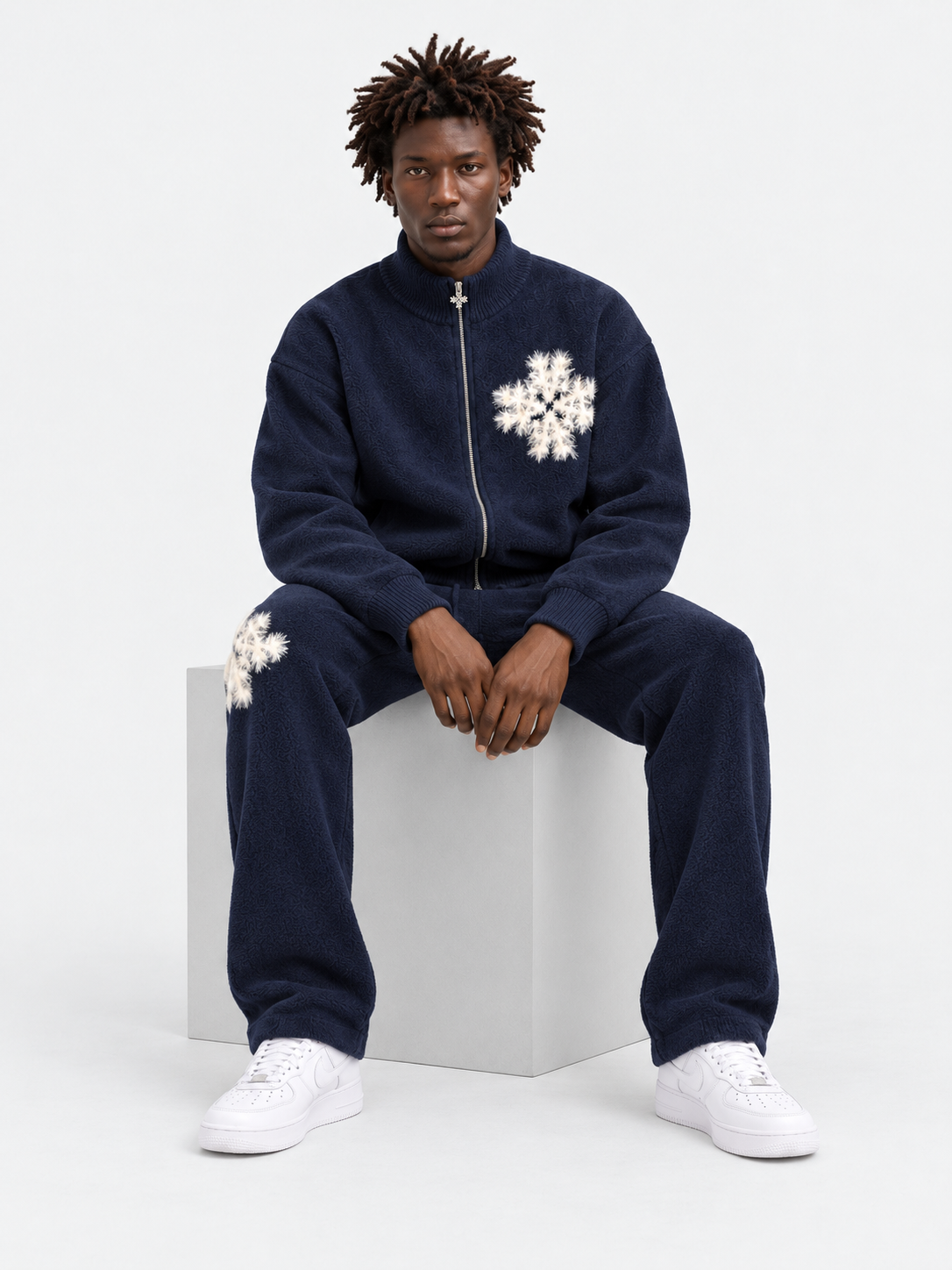 ATNT Tracksuits studio : Pantalon de jogging en maille fluffy monogramme signature navy, vue assise sur fond gris clair