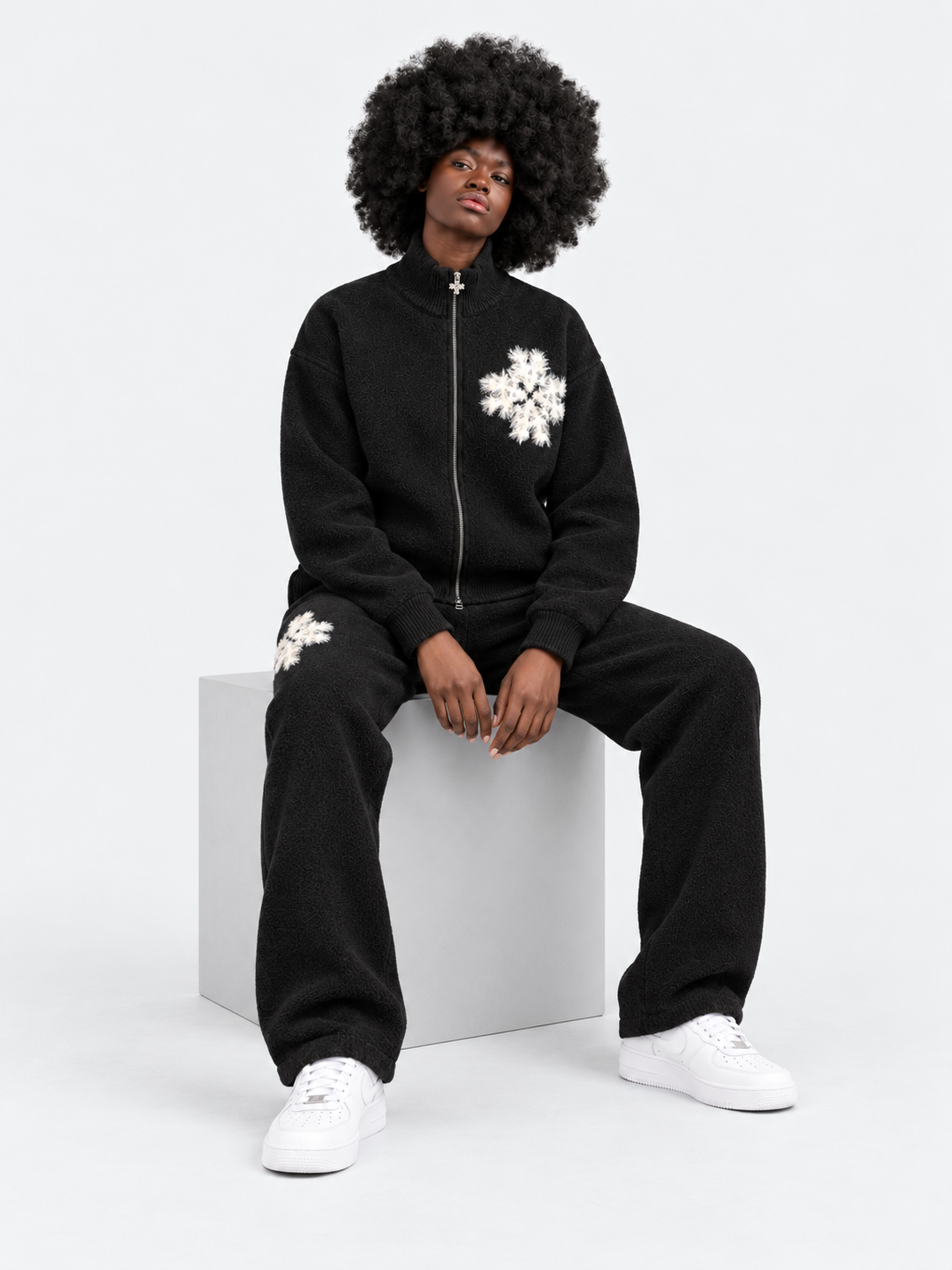 ATNT Tracksuits studio : Pantalon de jogging en maille fluffy monogramme signature noir, vue assise sur fond gris clair